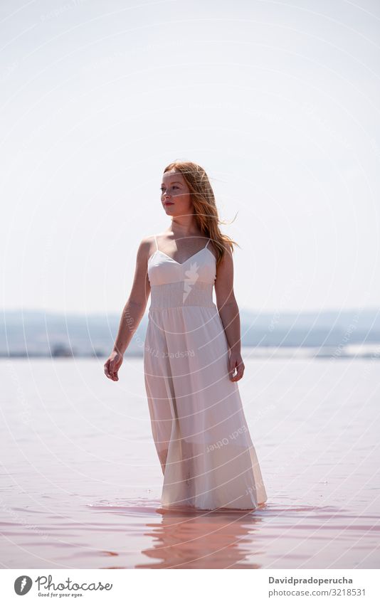 cute teenager woman wearing white dress standing on an amazing pink lake young romantic summer freckles happy alone sea colorful adolescent water copy space