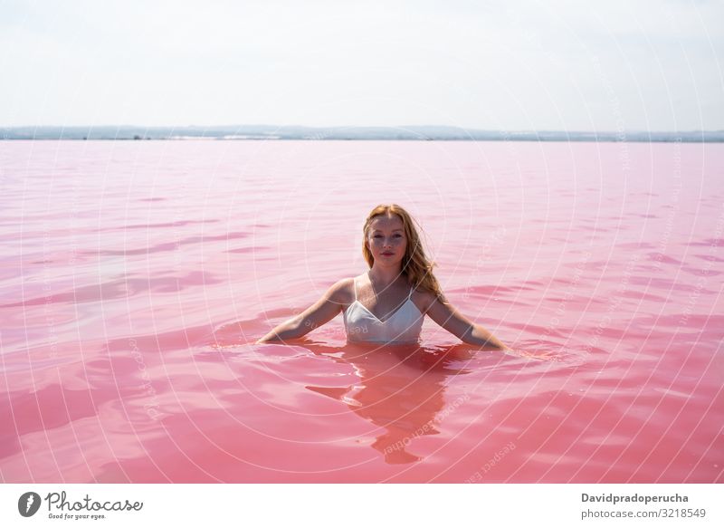 cute teenager girl wearing white dress in the water of an amazing pink lake woman stroll salty harmony mood romantic peace relax rest natural torrevieja