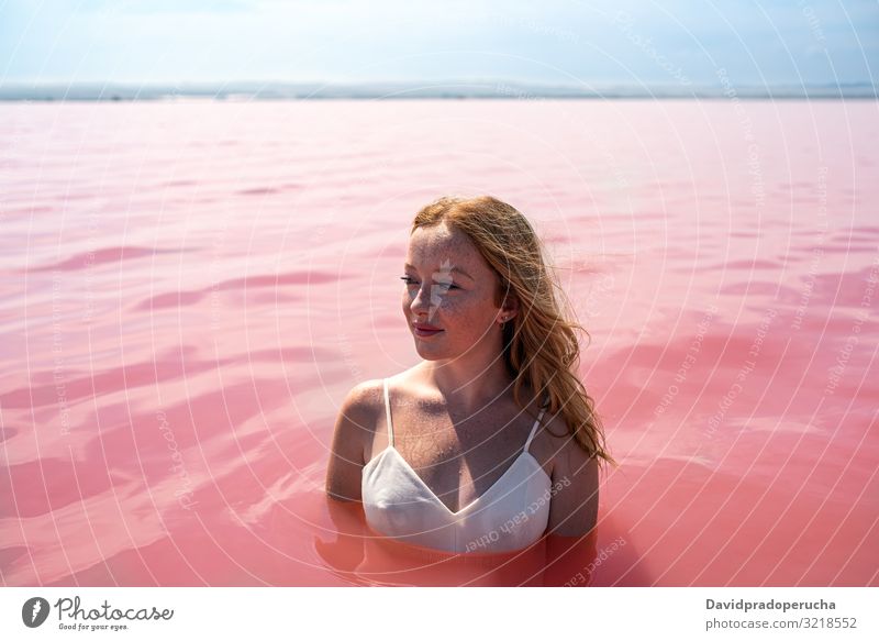 cute teenager girl wearing white dress in the water of an amazing pink lake woman stroll salty harmony mood romantic peace relax rest natural torrevieja