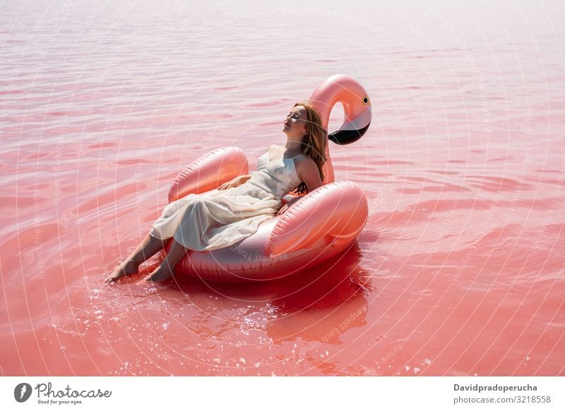 Beautiful woman lying on inflatable float mattress on pink sea female beach relax nature beautiful sunny cute young paradise salt halobacteria Spain water