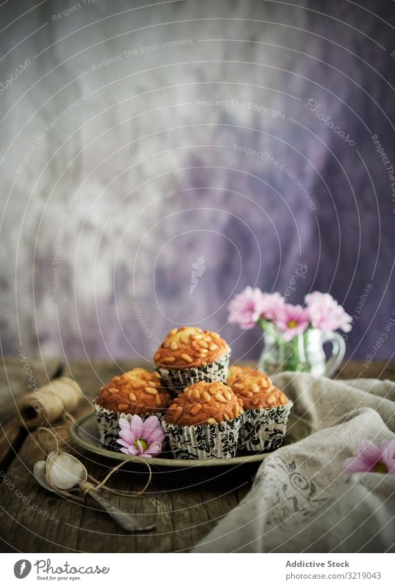 Grain cupcakes on table near flowers grain plate napkin rustic food vintage retro dessert muffin tasty delicious yummy stack bloom blossom flora linen cloth