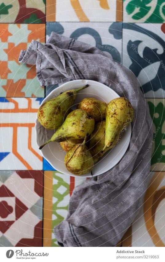 Napkin near bowl with pears ripe napkin ornament surface sweet food fruit fresh healthy delicious tasty yummy natural organic season juicy ingredient bunch