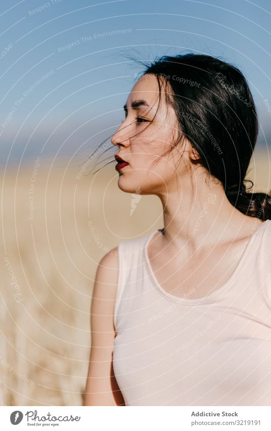 Asian lady standing in field woman windy nature asian weather sensual young summer freedom female meadow grass countryside harmony idyllic calm tranquil serene