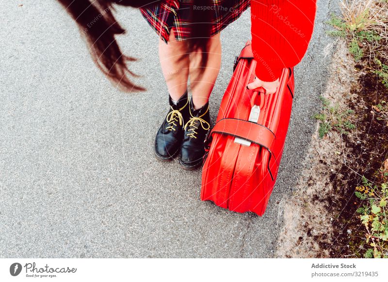 Woman in stylish boots with red suitcase standing on road woman legs travel luggage nature beautiful bag waiting freedom alone trip journey design tourist