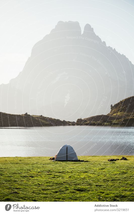 Majestic mountain landscape with tourist tent lake nature mountain range summit chain hill tourism travel scenic trip rocky stone top peak pyrenees ridge misty