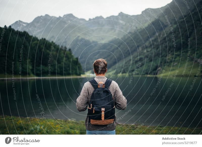 Anonymous man enjoying mountain landscape and lake tourist nature travel mountain range trip leisure summit male chain hill scenic rocky stone top peak pyrenees