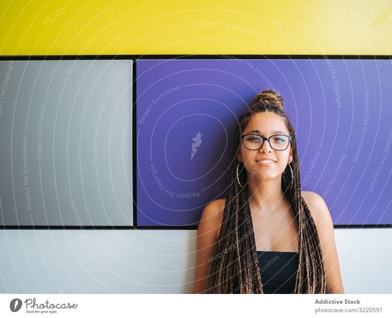 Charming teenage girl with braids in sunglasses nearby colorful wall earrings charming braided stylish teenager fun attractive fashion beautiful smart casual