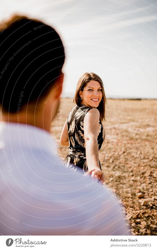 Loving couple in rye field summer meadow follow me happy walk delighted tender lover optimistic holding hands countryside nature smile together holiday romance