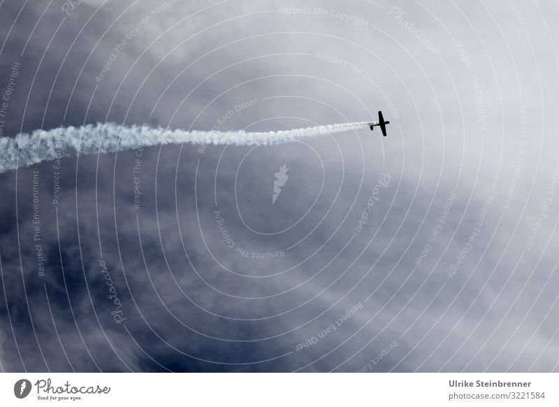 Small plane leaves condensation trails in the sky Model-making Aviation Sporting event Environment Nature Air Sky Clouds Storm clouds Summer Bad weather