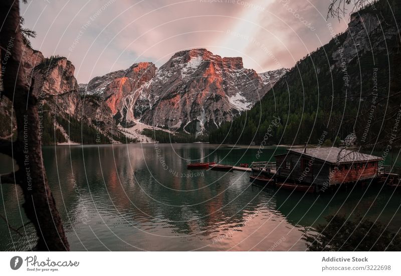 Houseboat surrounded with mountains on serene lake house picturesque travel nature water shabby houseboat vacation italy dolomites tourism scenery home scenic