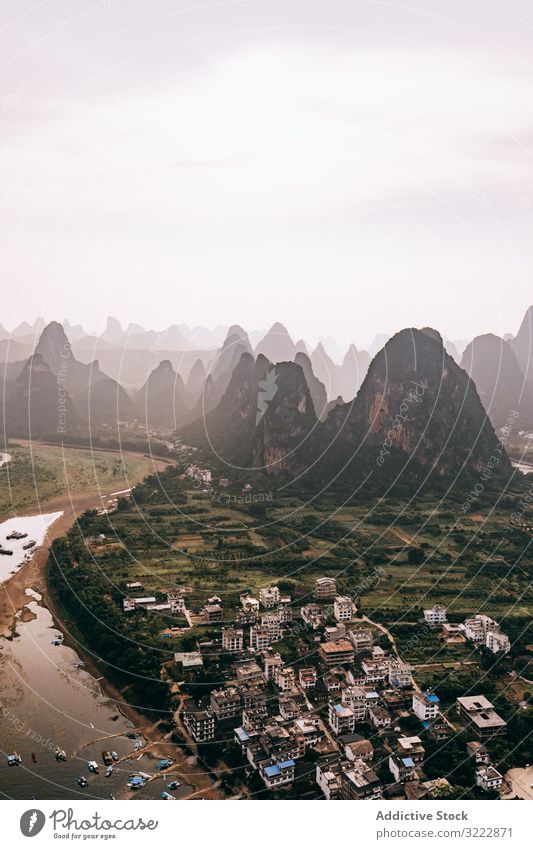 Coastal town surrounded with rocky mountains seaside coast travel bay remote drone view tourism architecture aerial green scenic small nature vacation beach