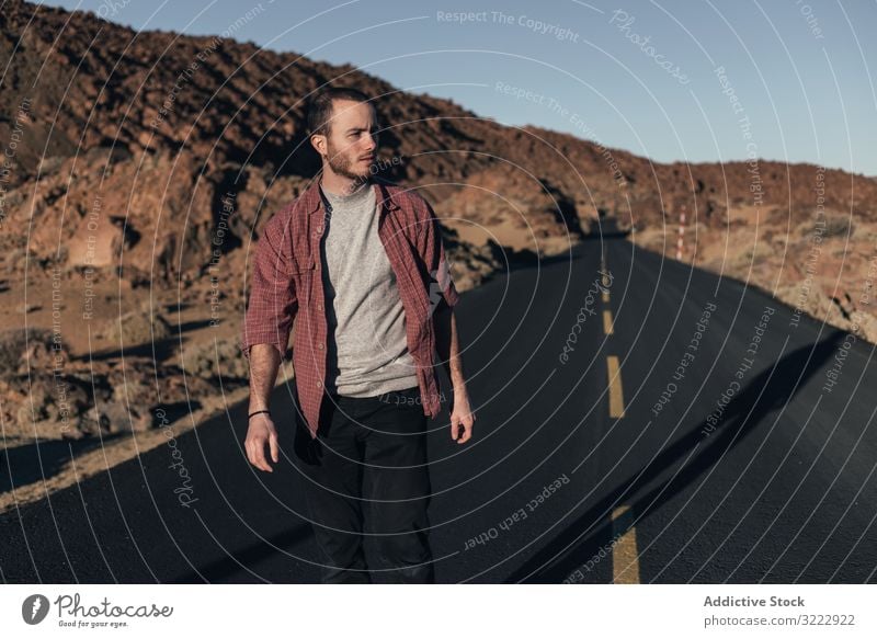 Man walking on mountain road on Tenerife Island man desert sunset solitude tenerife spain road trip young male handsome journey alone leisure wild nature travel