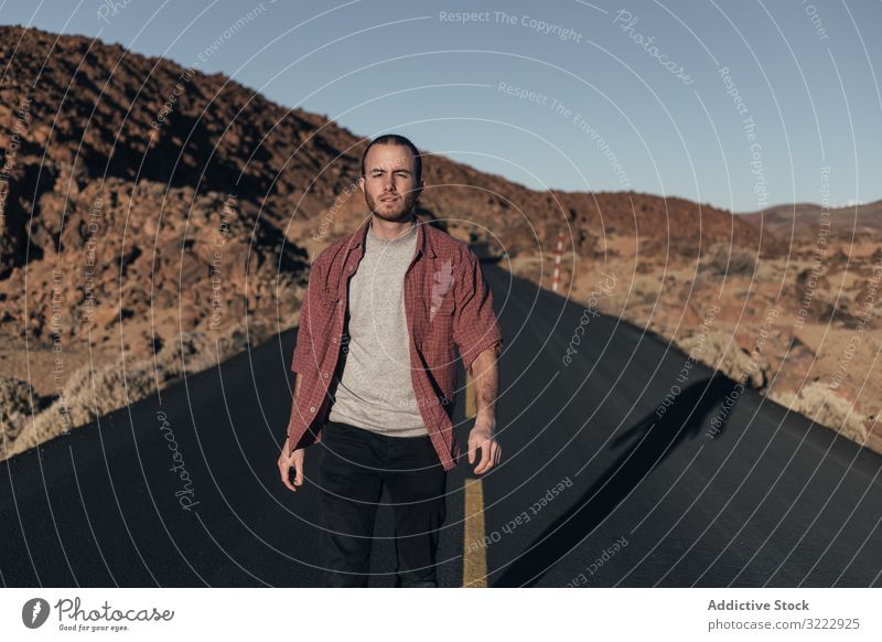 Man walking on mountain road on Tenerife Island man desert sunset solitude tenerife spain road trip young male handsome journey alone leisure wild nature travel