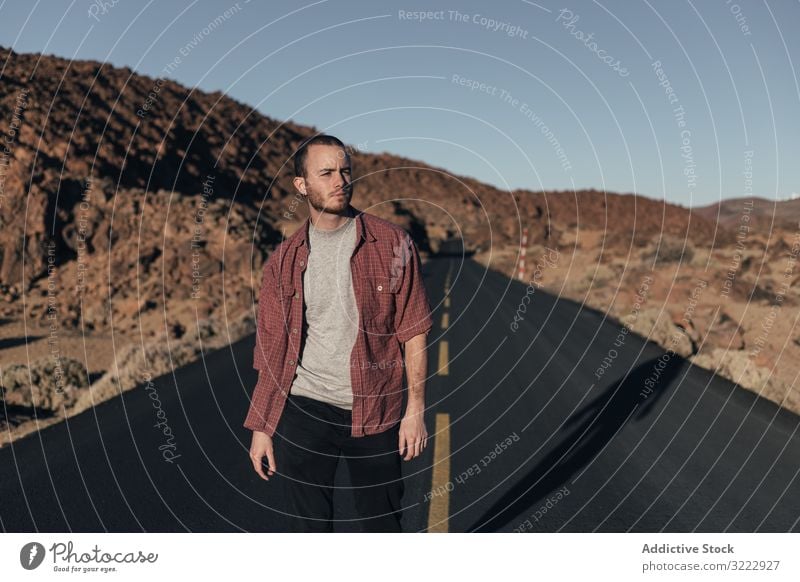 Man walking on mountain road on Tenerife Island man desert sunset solitude tenerife spain road trip young male handsome journey alone leisure wild nature travel