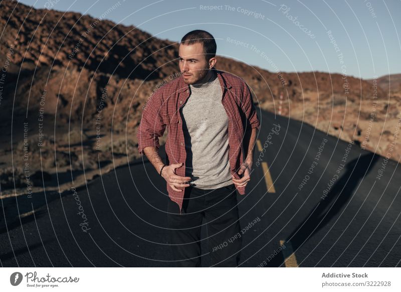 Man walking on mountain road on Tenerife Island man desert sunset solitude tenerife spain road trip young male handsome journey alone leisure wild nature travel