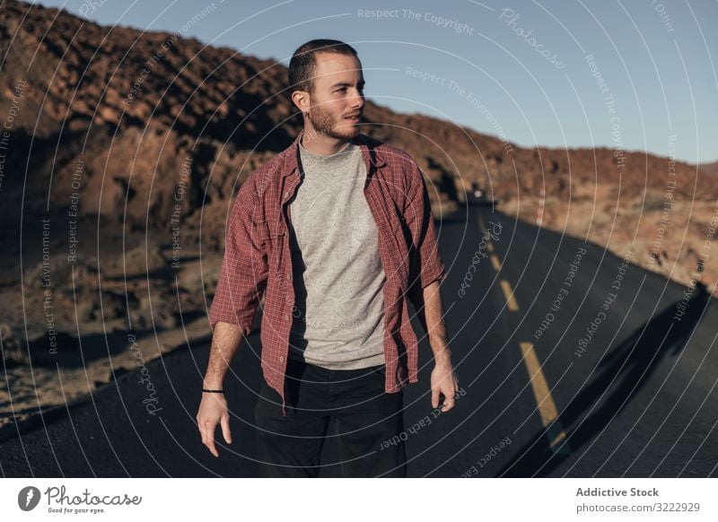 Man walking on mountain road on Tenerife Island man desert sunset solitude tenerife spain road trip young male handsome journey alone leisure wild nature travel