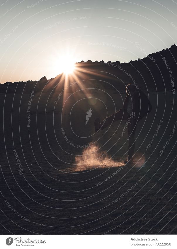 Man during sunset on deserted land traveler sand tenerife dust kick up sunlight flare trip spain adult man explore motion bored dawn nature vacation leisure