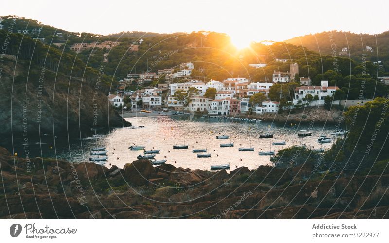 Sunrise over southern town on seaside bay scenery shore resort sunrise water ocean landscape nature morning hill coast exterior tourism travel trip village boat