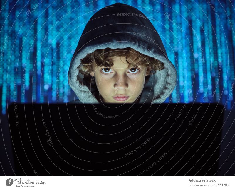 Little hacker looking at camera laptop code boy database little using computer programmer virus digital password software kid child device gadget browsing