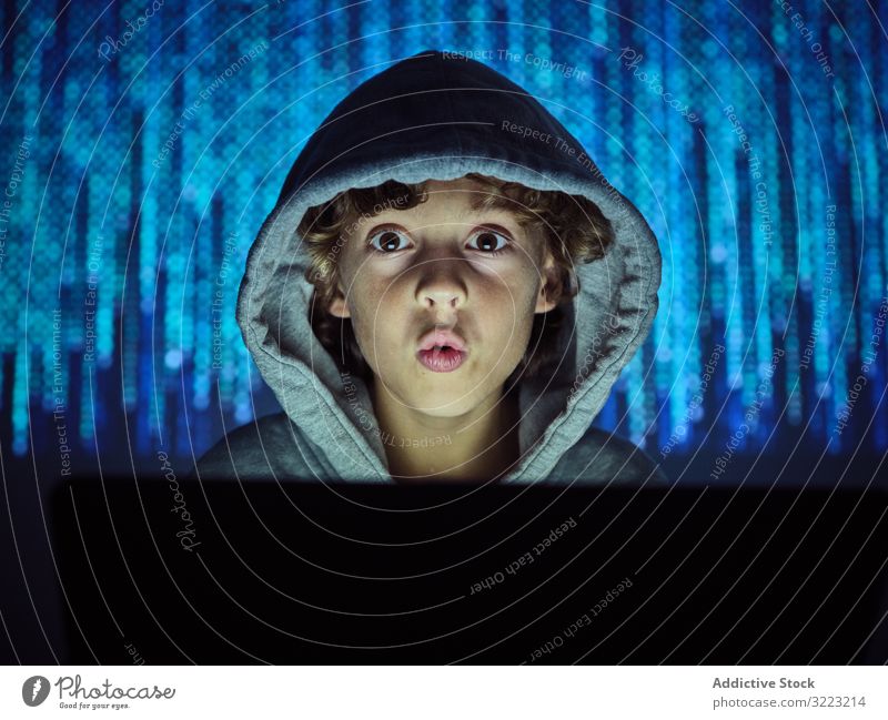 Little hacker looking at camera laptop code boy database little using computer programmer virus digital password software kid child device gadget browsing