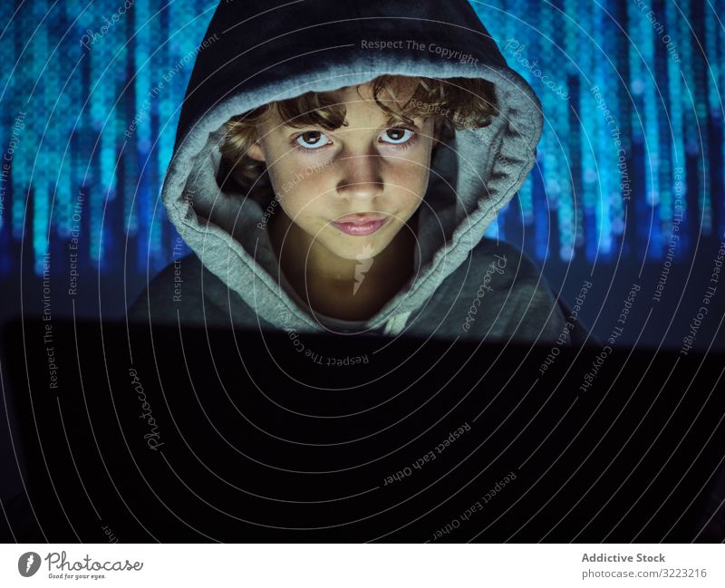 Little hacker looking at camera laptop code boy database little using computer programmer virus digital password software kid child device gadget browsing