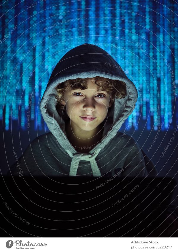 Little hacker looking at camera laptop code boy database little using computer programmer virus digital password software kid child device gadget browsing