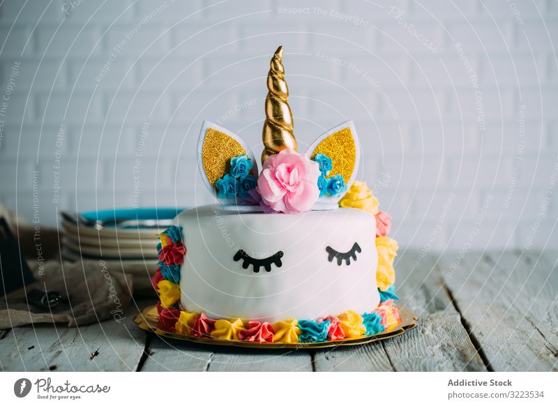 Cute unicorn cake with painted closed eyes sweet tasty birthday bright table appetizing holiday decoration gourmet yummy childhood event festive funny cooking