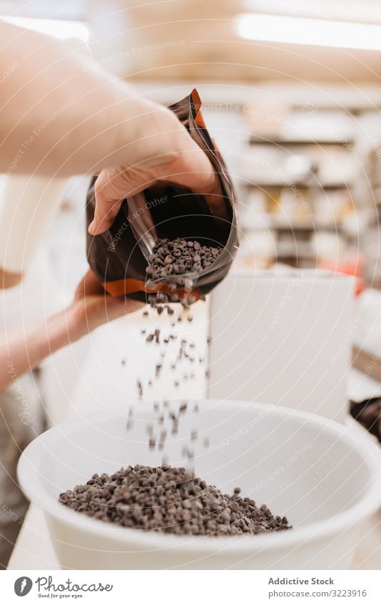 Crop confectioner spilling chocolate into bowl bakery callet industry pastry sweet professional dessert culinary cuisine chef food fresh bag ingredient