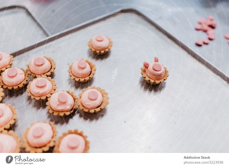 Pig shaped pastry on tray dessert bakery pig symbol small pink cake ear snout food sweet fresh small business event preparation decor patisserie commercial