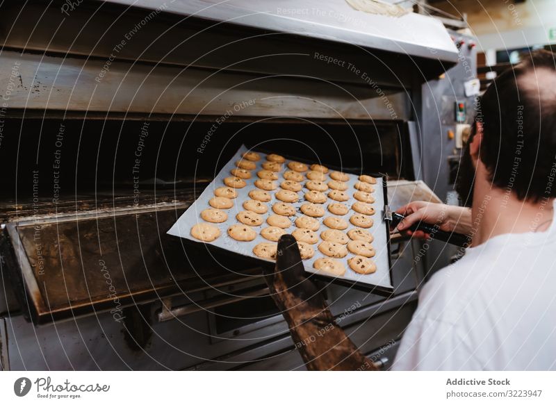 Bald baker checking pastry inside oven man bakery peek work confectioner cook hot process male adult uniform cuisine small business wait heat warm equipment