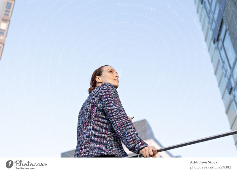 Serious businesswoman leaning on railing building street office serious city elegant modern urban female concerned manager entrepreneur career exterior jacket