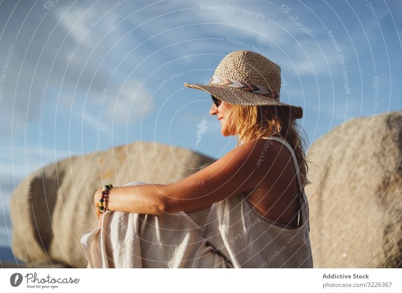 Carefree lady enjoying rest on coast near cliffs woman carefree travel optimistic seaside happy smile hat trip vacation gorgeous sunglasses recreation cheerful