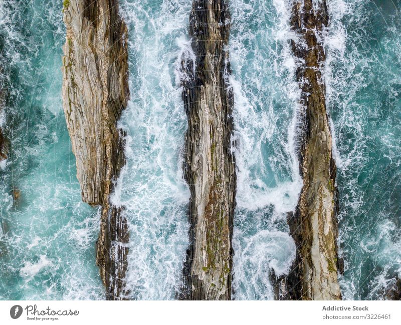 Stone ridges on high seas in stormy day ocean scenic nature nautical dramatic rocky water coast travel tourism natural dangerous turquoise aquatic mountain