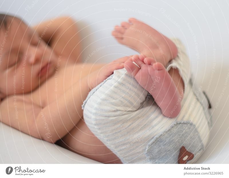 portrait of baby asleep in bed home bucket concept barefoot innocence infant knitted warm child newborn calm tranquil serene peaceful crossed legs quiet silence