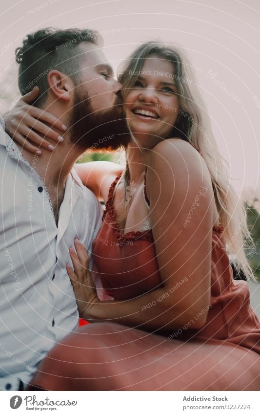 Loving couple sitting on car on road near forest hug roadtrip tourism love flirt travel embrace together adventure summer hood transport explore countryside