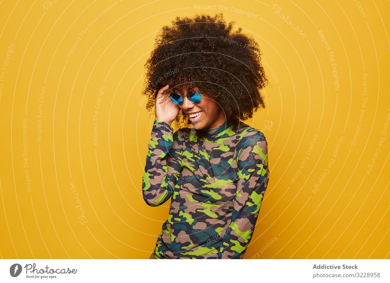 Trendy ethnic lady in sunglasses on bright backdrop woman colorful cool afro trendy vibrant happy vivid outfit modern hipster millennial attractive black