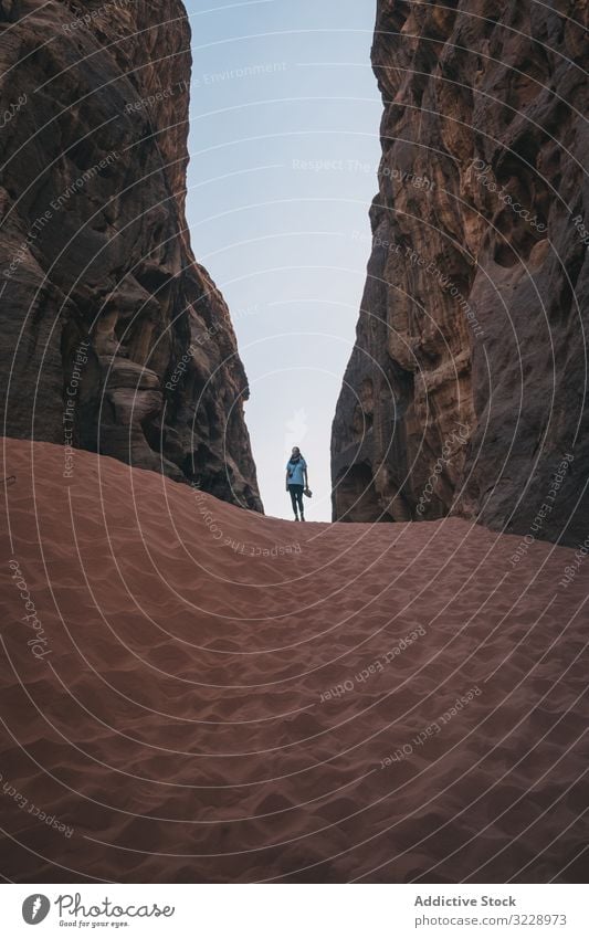 Unrecognizable lady in sandy ravine traveler desert sky cloudless woman wadi rum jordan wall surface adventure trip journey cliff tourism rock scenic formation