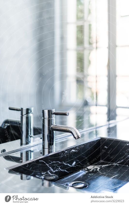 Marble sink and water tap in contemporary washroom bathroom marble washbasin faucet luxury metal detail mirror tile stainless tub rectangular steel hygiene