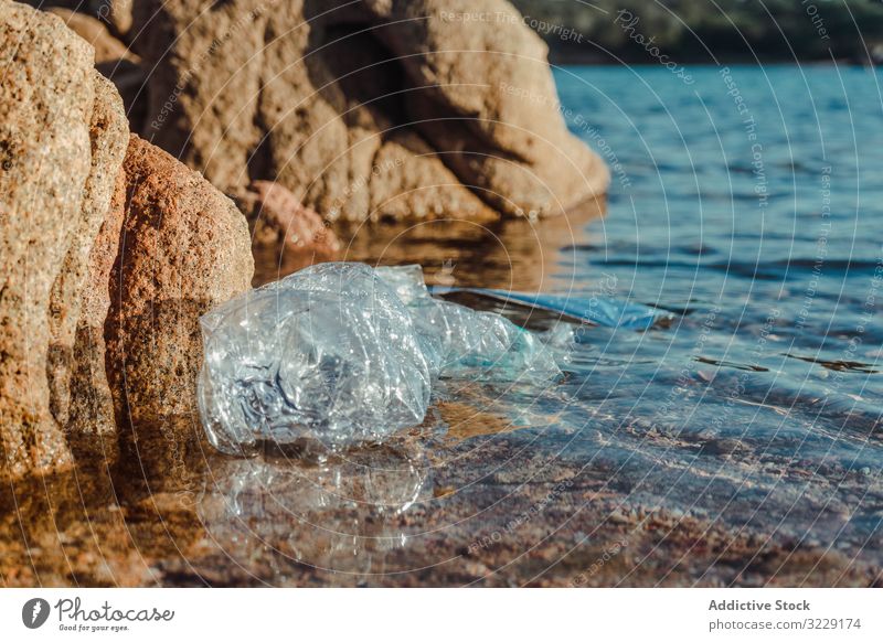 Plastic bottle lying on seashore plastic waste ecology nature beach pollution trash dirty harmful garbage litter rubbish sand marine hazard environment