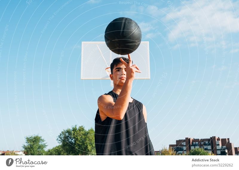 Young man playing on yellow basketball court outdoor. athlete competition sports equipment adult recreation action portrait active activity asphalt athletic