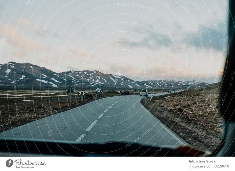 Road trip on cloudy day road vehicle sky hill plain morocco africa weather nobody car window vacation journey travel tourism auto transport windshield