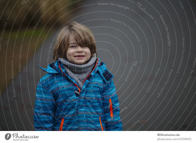 Boy laughs on an autumn day Boy (child) Child Jacket Autumn Blue Laughter Hair and hairstyles Gray Gloomy Autumnal portrait Infancy Nature out Weather fun Joy