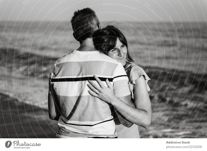 Adult couple embracing near sea beach resort love hug date smile happy vacation man woman adult honeymoon summer shore coast relationship water embrace ocean