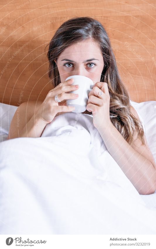 Girl in a bed with a cup of coffee pretty awake joy girl beauty indoors view home lying down sleep rest lifestyle beautiful waking young awakening morning