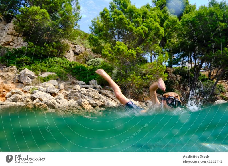 Little boy getting ready to jump in water sea dive summer seashore balance child mask coast travel active rocky tourism cliff sporty recreation wet energy