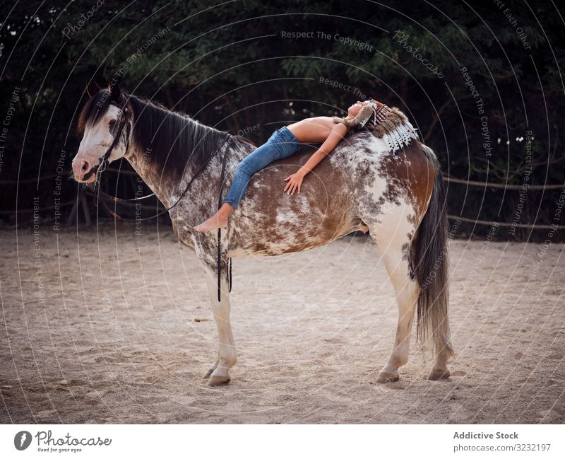 Peaceful child daydreaming while lying on horse boy harmony authentic war bonnet horseback love kind indian costume meditation innocence inspiration caress