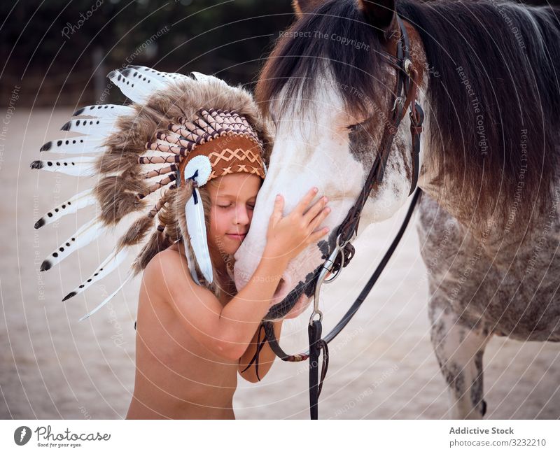 Tender boy hugging horse at farm bonding child tender authentic harmony war bonnet kind stallion indian love touch costume caress concentrated stroke shirtless