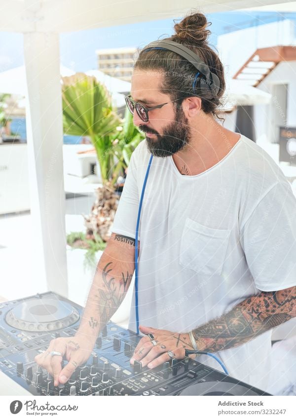 DJ playing music at party man dj headphones fun controller set turntable mix song gig concert electronic event summer leisure job hobby male handsome hipster