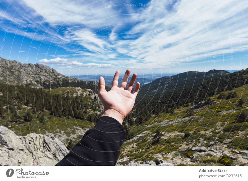 Person stretching hand to blue sky above mountain valley nature travel park forest landscape scenic hill rocky rural green scenery beautiful serenity peaceful