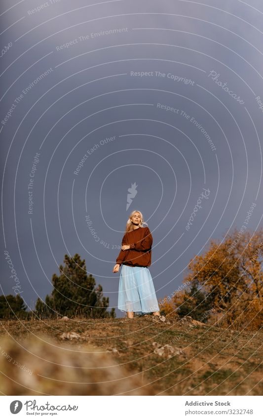 Beautiful blonde walking along autumn countryside woman style trendy elegant rural chilly cold skirt beautiful young adult calm tranquil peaceful nature